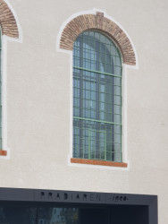 Hladké fasády silocentrály traktují charakteristická industriální okna s výraznými nadlehčovacími oblouky