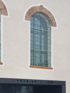 Hladké fasády silocentrály traktují charakteristická industriální okna s výraznými nadlehčovacími oblouky