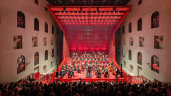 Do historických lázní vstoupila červená konstrukce, vznikl nový koncertní sál. Stavěla se ručně přímo na místě a usadí se na ni 330 lidí. (Koncertní sál v Císařských lázních v Karlových Varech, Petr Hájek ARCHITEKTI, 2023) 