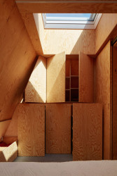 S antracitovým plechem z vnějšku kontrastuje dřevěný interiér, působí to "chatařsky". (Chata v Posázaví, Atelier Hajný)