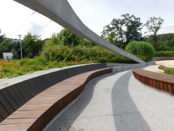  Prostor je ohraničen porostlými kopci a lemem vestavěných laviček.