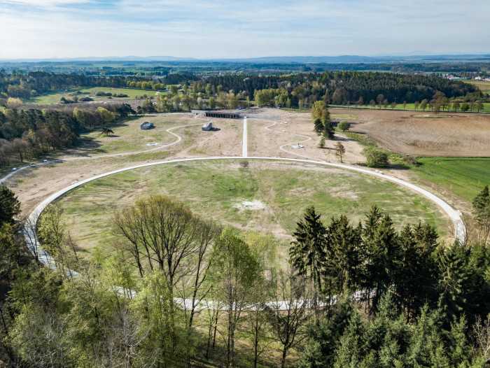 Památník v Letech u Orlické přehrady. Hlavní je louka a les.