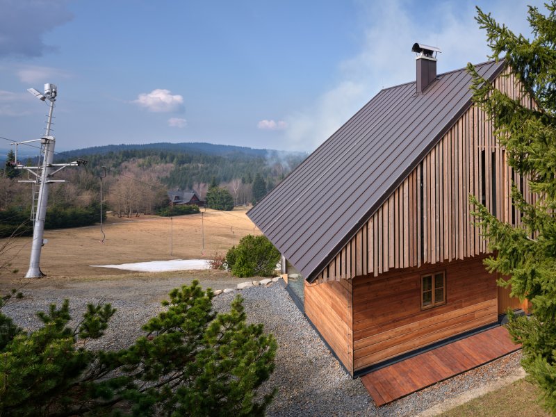 Chata stojí pod vrcholem Kohútky v Javornících, hned u lyžařských vleků. (Chata Kohútka od SENAA architekti)