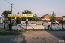 Skatepark Jeneč, U/U studio: Odkaz k autobazaru areálu autoři připomněli jeho starou cedulí, kterou zrecyklovali a v podobném duchu přetřeli nápisem „Skatepark Jeneč“