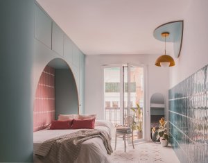 Hlavní obytný prostor tvoří obývací pokoj s jídelním stolem, gaučem a postelí. Je tu také okno, ústící na balkon. (TUR House, OOIIO)