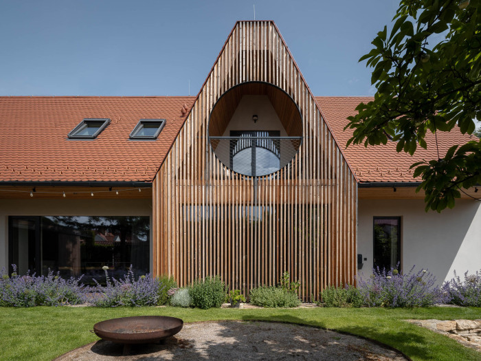 Dům ve Střešovicích má tradiční proporce i současné prvky, třeba kulaté okno v podkroví. (Rodinný dům v Břevnově; OTA atelier)