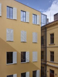 Od původní budovy je dostavba oddělená prosklenou výtahovou šachtou