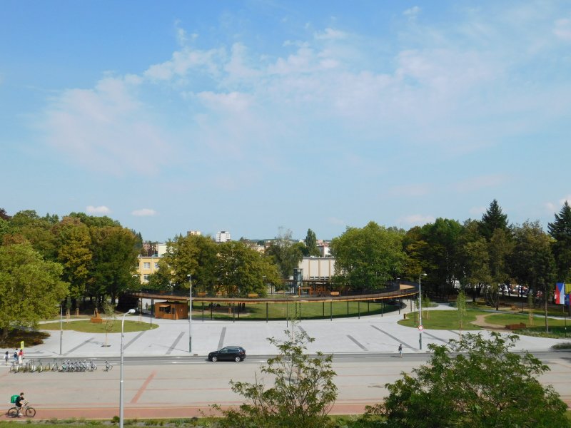 Před prstencem je plocha z velkoformátové dlažby, která opět slouží ke konání akcí, naopak parkování podél cesty bylo zrušeno.