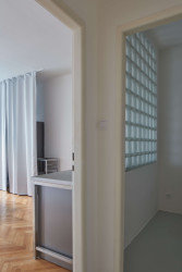 Stěna z luxfer je nová, ačkoliv vypadá, že tady mohla být už původně, k domu ze 30. let se hodí. - Byt v Praze na Letné, Prokop Hartl