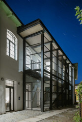 Pod střechou vykukuje obložení z heraklitu, tento materiál je také na výtahové šachtě a objevuje se i v interiéru. (Komunitní centrum ve Strakonicích, Ateliér VAS)