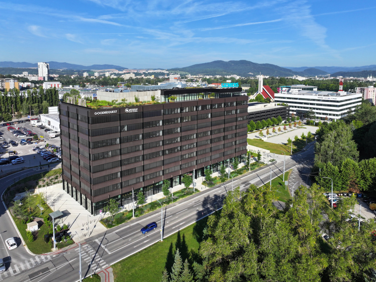  Obchodná je založená na jednoduchém kubickém objemu, měřítko odlehčují souvislé horizontální pásy skla a rastrované fasády. (Administrativní budova NORDCITY Obchodná v Žilině; ateliér Endorfine, developer Reinoo)