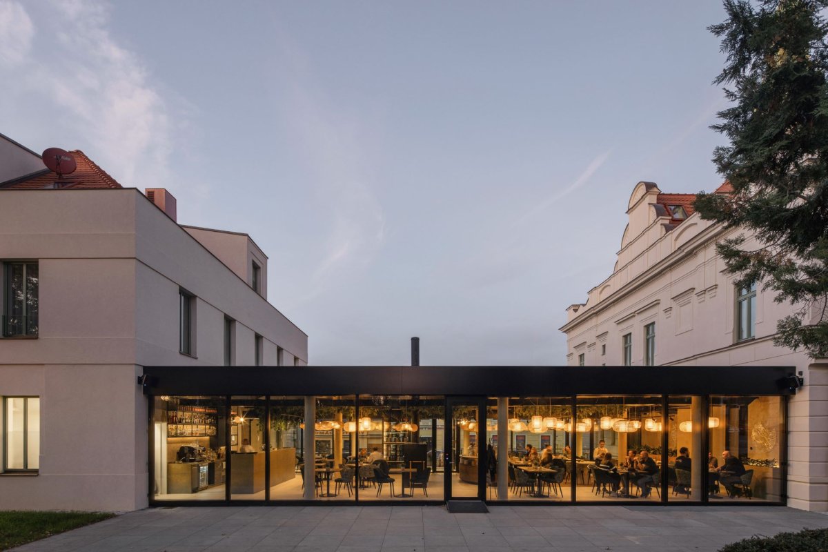 Skleněné stěny restaurace umožňují kolemjdoucím nahlédnout dovnitř a zároveň propojují interiér s exteriérem. (Villa Fitz v Rokycanech, Luni architekti)