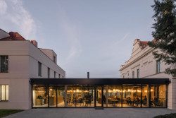 Skleněné stěny restaurace umožňují kolemjdoucím nahlédnout dovnitř a zároveň propojují interiér s exteriérem. (Villa Fitz v Rokycanech, Luni architekti)