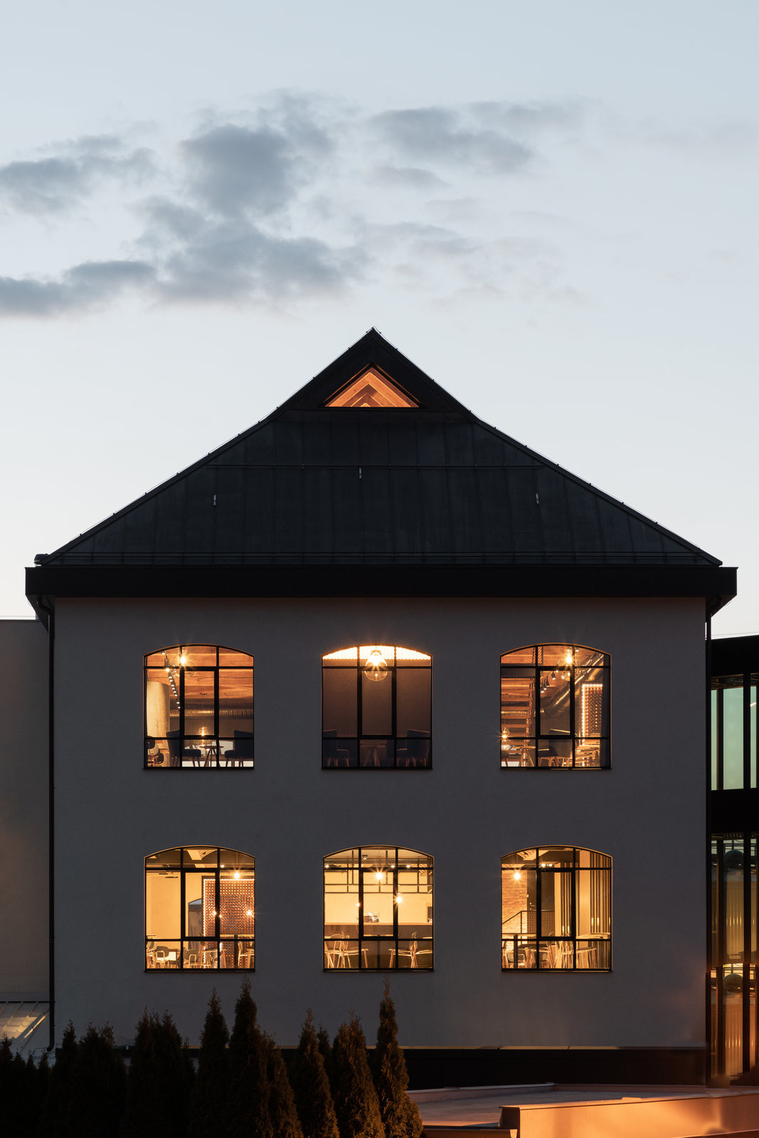 Novostavba Návštěvnického centra v pivovaru Bernard s dělenými okny a prosklenými výkladci. (Interiér pivnice Bernard v Humpolci; B² Architecture)
