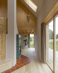 Přízemní patro člení pouze dřevěné schodiště a krb umístěný uprostřed domu. (Casa De Mi Luna, Studio Circle Growth)