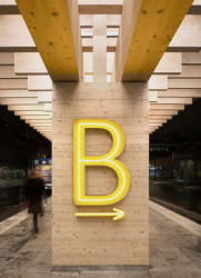 Jednotlivá nástupiště označují neonově svítící písmena. (Autobusové nádraží Umeå Vasaplan, Wingårdhs + WSP)