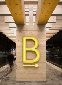 Jednotlivá nástupiště označují neonově svítící písmena. (Autobusové nádraží Umeå Vasaplan, Wingårdhs + WSP)