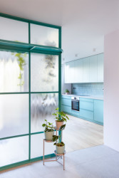 Dominantním prvkem interiéru je prosklená příčka v tyrkysové barvě. (Rekonstrukce panelákového bytu; Markéta Janderová)