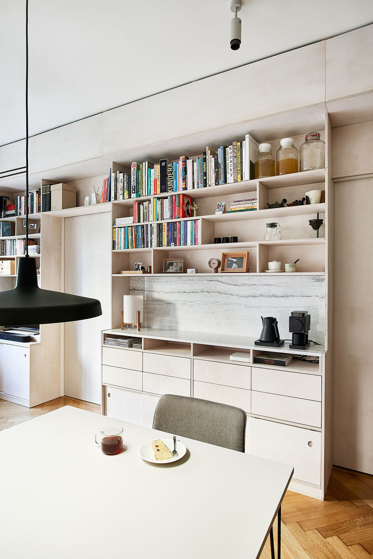 Majitelé jsou velkými milovníky kávy. Tu výběrovou si připravují v kávovém koutku, který je součástí knihovny. (Rekonstrukce bytu na Vinohradech, Markéta Bromová architekti)