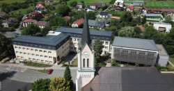 Nástavba základní školy Vidče vyřešila nedostatek prostor pro výuku. Pracuje s kontrastem mezi tmavou současnou vrstvou a původní světlou fasádou z 80. let.