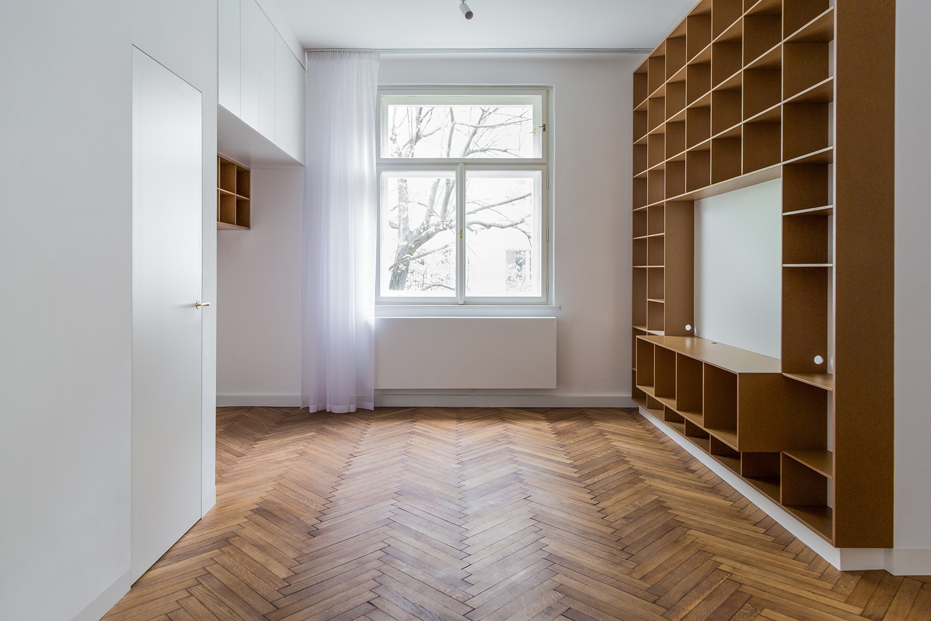 Byt je po rekonstrukci jako nepomalované „bílo-hnědé plátno“ - zatím je totiž určený k pronájmu. (Rekonstrukce bytu v Praze, BY architects)