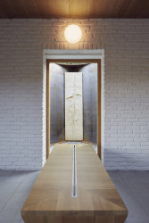 Dva surové ocelové pláty objímají původní plastiku. (Smuteční síň ve Vimperku, Jakub Vašek)