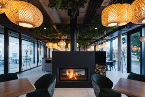 Dominuje masivní krb, designové osvětlení a bar obložený kamenem. (Villa Fitz v Rokycanech, Luni architekti)
