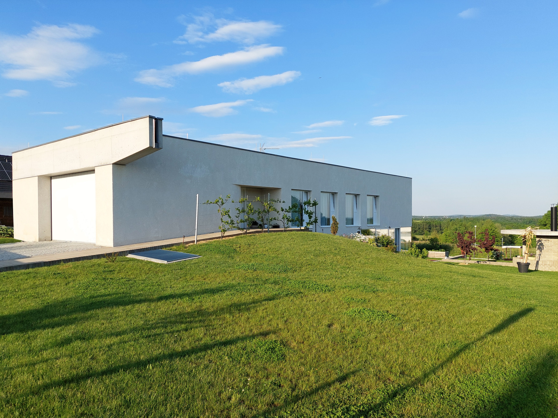 Dům s rampou, Prokš Přikryl: Poetickým prvkem jinak strohé vstupní fasády s garáží, je betonový chrlič vody doplňující figuru domu