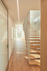 Rodinný dům u Pardubic, 0,5 Studio: Hala se schodištěm tvoří předěl mezi obytným prostorem a provozní částí s ložnicí,