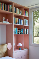 Pohled do ložnice, které dominuje růžová nábytková stěna. (Byt v paneláku od hurá studio)