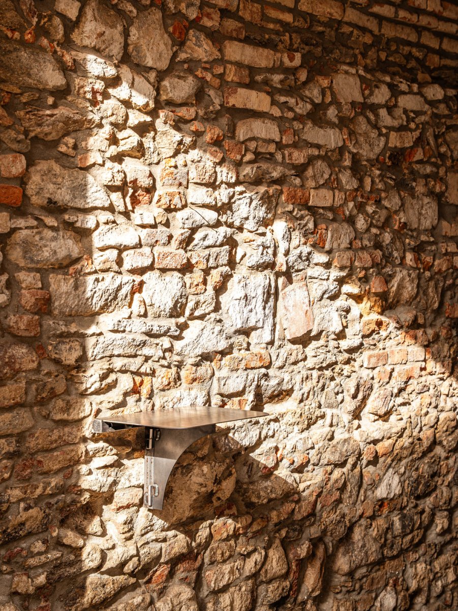 Staré části doplnil současný design. Zde stoleček v průjezdu