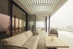 Kryté posezení s výhledem na bazén a krajinu propojuje interiér s exteriérem a podtrhuje klidnou atmosféru domu. (Bungalov ve východních Čechách; Atelier Kunc)