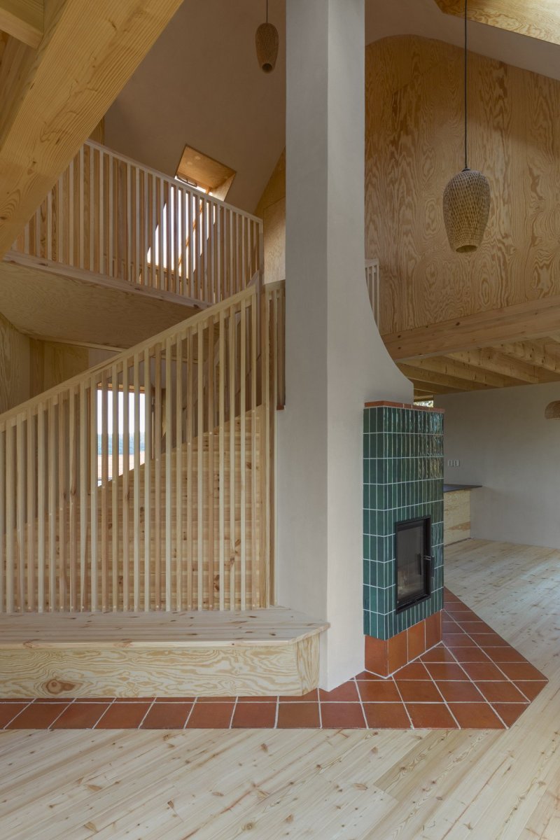 Přízemní patro člení pouze dřevěné schodiště a krb umístěný uprostřed domu. (Casa De Mi Luna, Studio Circle Growth)