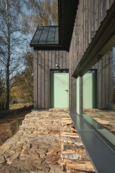 Chata má velká okna - přáním investorů bylo mít zevnitř velkorysé výhledy do krajiny. (Chata na Šumavě, ateliér Markéty Cajthamlové)