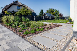 Chodníček z nášlapných kamenů ALMA zasazený v kamínkovém loži usnadňuje vsakování dešťové vody. Skladebná dlažba ALTERNO je ideální i pro mírně zatěžované plochy občasným pojezdem automobilů, Presbeton - foto