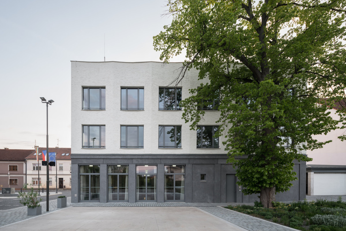Detail vztahu budovy k náměstí - objekt působí jako přirozený organizující prvek veřejného prostoru. (Nová radnice s plastickou fasádou; re:architekti)