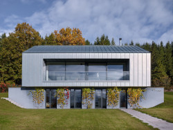 Při pohledu na dům ze spodní části pozemku se objevuje podnož.  (Rodinný dům u Klatov; Stempel Tesař architekti )