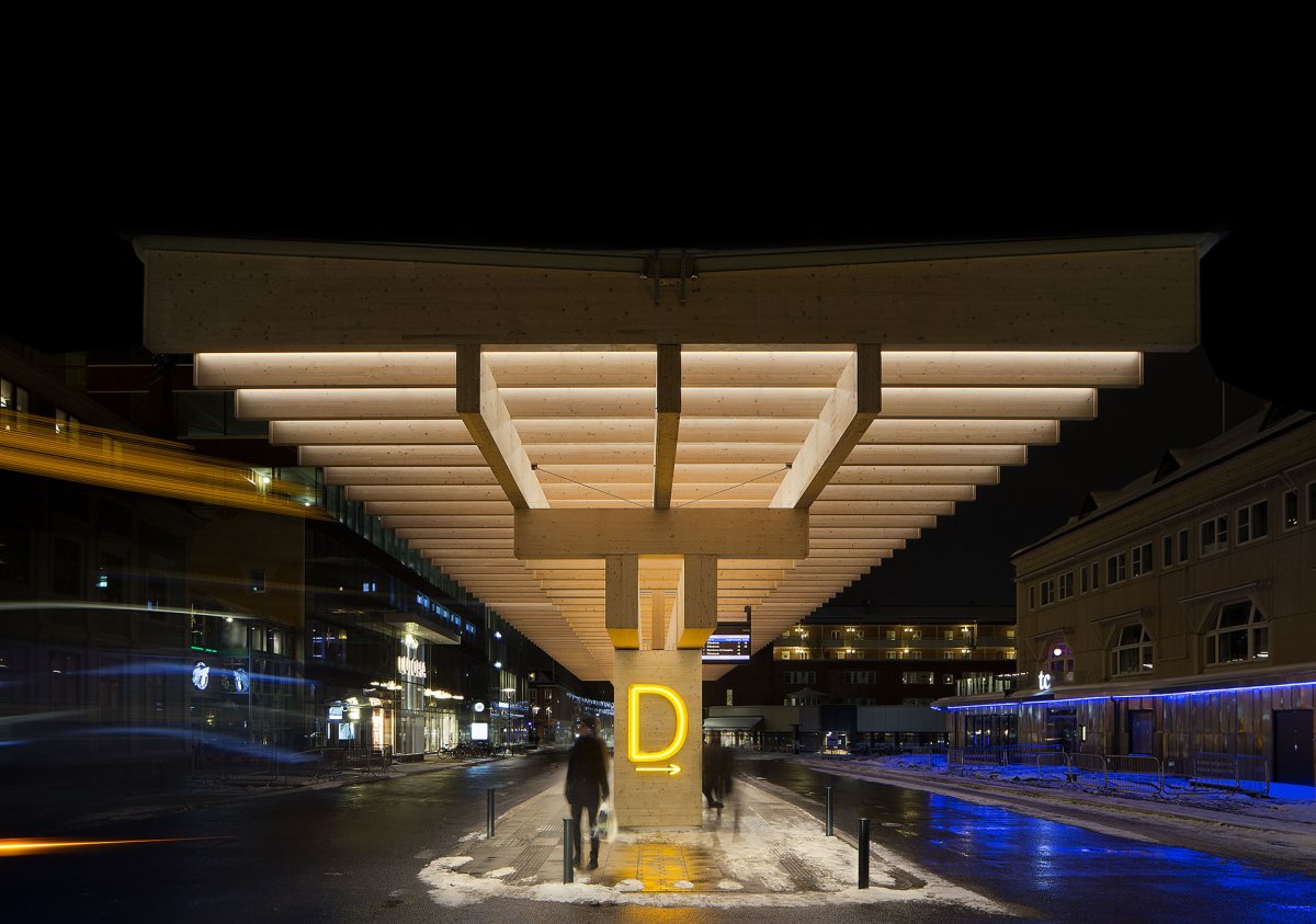 Jednotlivá nástupiště označují neonově svítící písmena. (Autobusové nádraží Umeå Vasaplan, Wingårdhs + WSP)