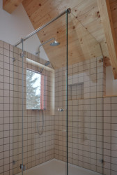 V podkroví se nachází malá koupelna ve znamení dřeva a bílých kachliček. (Chata Bučina v Malé Úpě, studio ADR)