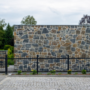 Stavba hned za branou tiše plní svou funkci a nenásilně zastiňuje parkoviště. (Zázemí hřbitova; bydloarchitekti)