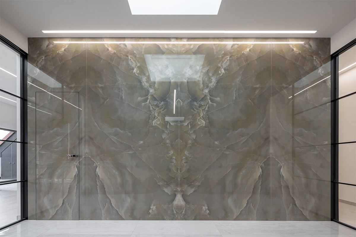 Obložení stěny onyxovým mramorem nenarušují ani dveře; unikátní konstrukce dveří MASTER umožňuje na jejich opláštění použít stejný materiál.