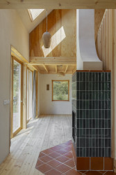 Krb je obložen zeleným obkladem a je situován strategicky tak, aby se teplo rovnoměrně šířilo po celém domě. (Casa De Mi Luna, Studio Circle Growth)