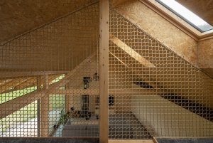 Obytné podkroví je propojeno s jídelnou. (Víkendový dům v Českém ráji, NEW HOW Architekti)