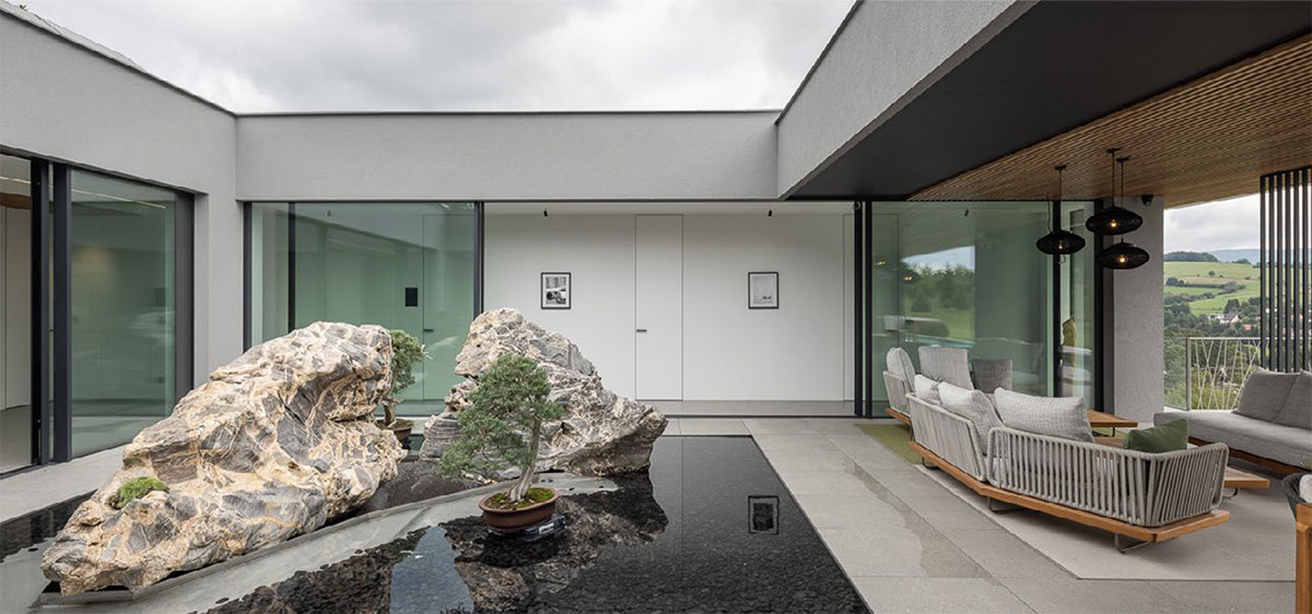 Hlavní atrium s půltunovými kameny a bonsajemi je srdcem domu.