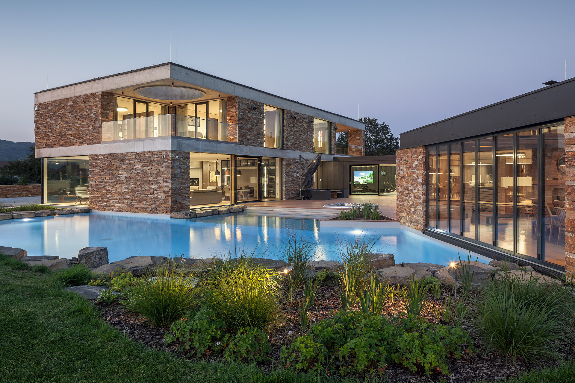 Vilu tvoří dvě na sebe kolmé hmoty. Obytná část je řešena jako dvoupodlažní hranol, ke kterému je kolmo přisazeno křídlo s krytým bazénem