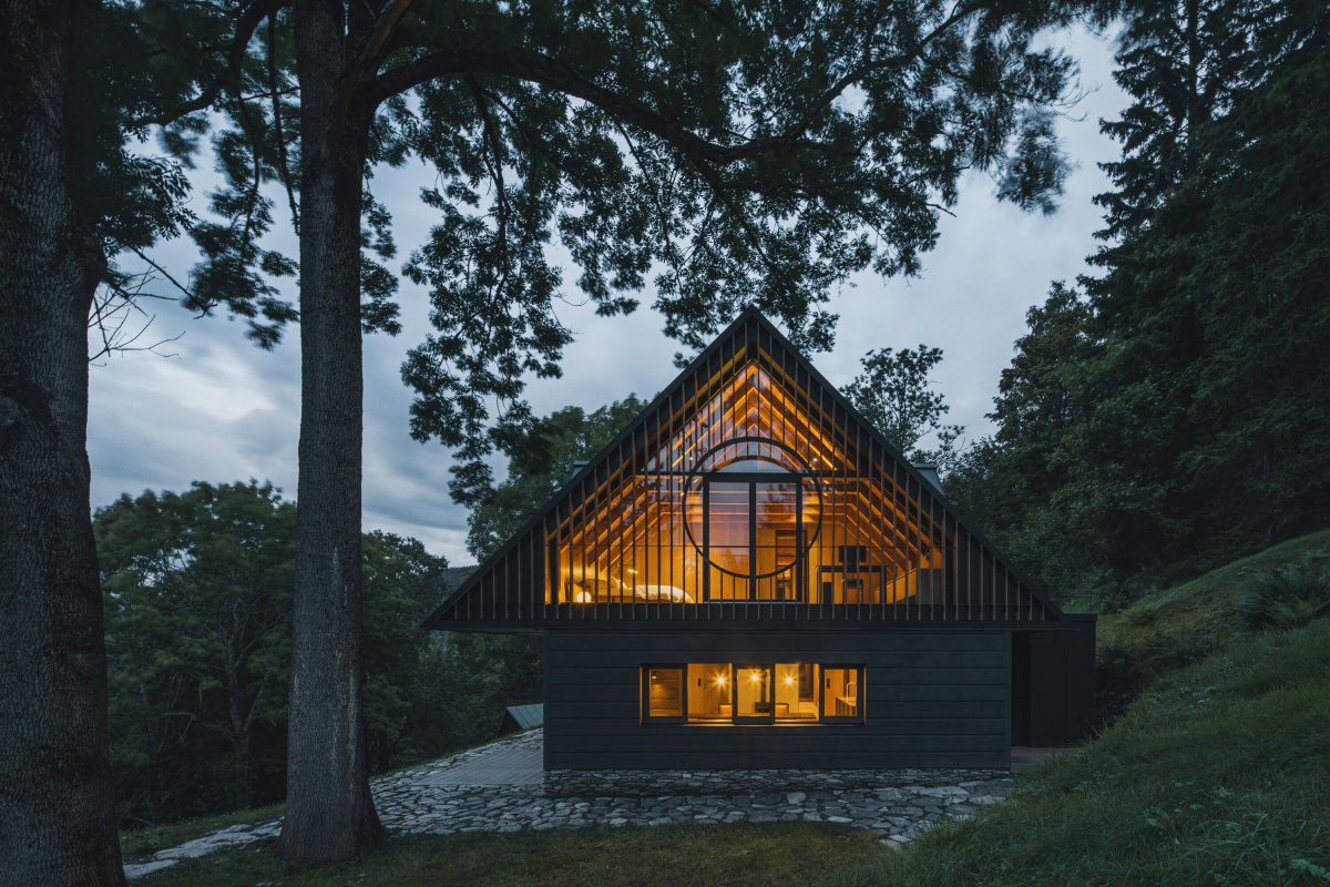 Večerní pohled zdůrazňuje otevřenost podkroví a propojení interiéru s okolní krkonošskou krajinou. (Chalupa ve stráni; Mimosa Architekti)