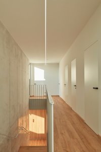 Rodinný dům u Pardubic, 0,5 Studio: Odlehčené schodiště s betonovou stěnou prostupuje celým prostorem z haly do prvního patra s dvěma dětskými pokoji, pokojem pro hosta a hygienickým zázemím