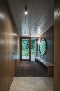 Interiér pracuje s přírodními materiály, tlumenou atmosférou a průhledy do okolní krajiny. (Chalupa ve stráni; Mimosa Architekti)
