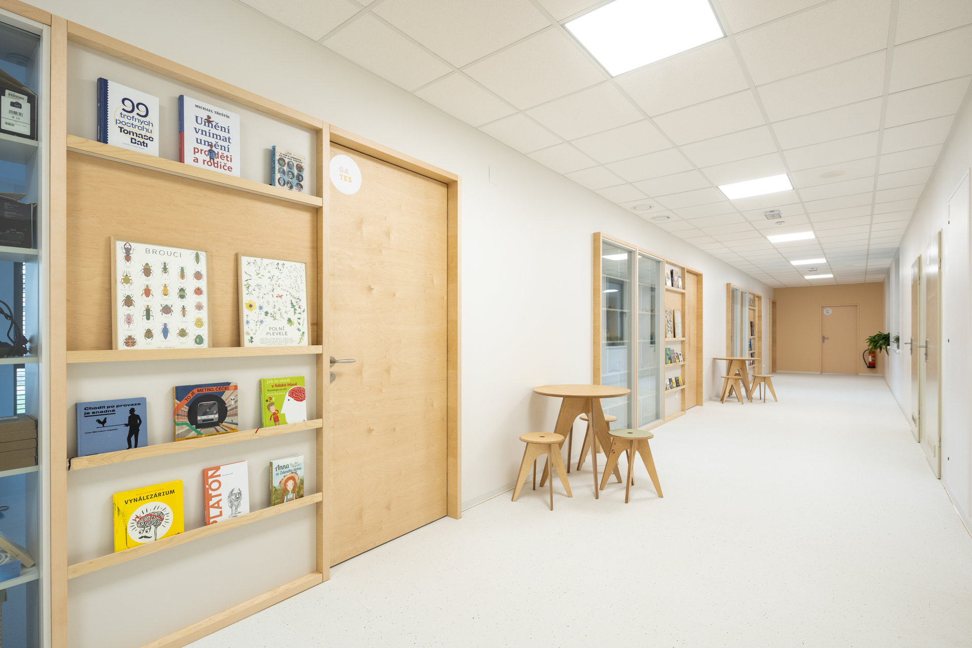 Prosklené stěny mezi třídami prostor ještě více otevírají a sousední knihovna mu dodává útulnost. (ZŠ Jinotaj ve Zlíně)