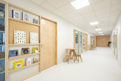 Prosklené stěny mezi třídami prostor ještě více otevírají a sousední knihovna mu dodává útulnost. (ZŠ Jinotaj ve Zlíně)